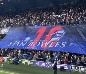 Large custom football crowd surfer flag displayed by supporters in a stadium