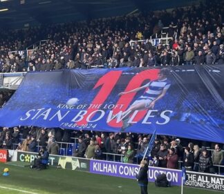 Large custom football crowd surfer flag displayed by supporters in a stadium