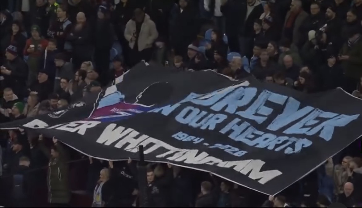 Large custom football crowd surfer flag displayed by supporters in a stadium